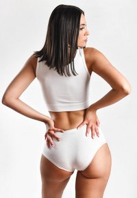 Weißes Baumwoll-Crop-Top und hochgeschnittene Unterhosen. Glatte Textur, figurschmeichelndes Design, mittelschwerer Stoff und minimal auffällige Nähte.