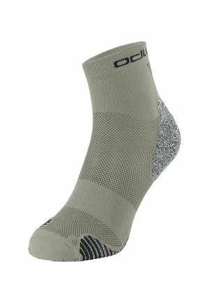 Graue Knöchelsocke mit strukturiertem Strick, verstärktem Fersen- und Zehenbereich in Schwarz und Weiß, versehen mit einem schwarzen Logo nahe dem Bund.