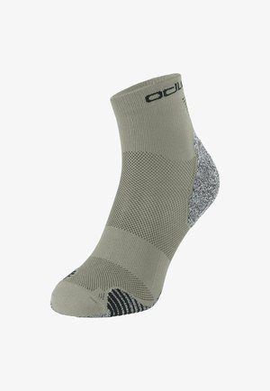 Graue Knöchelsocke mit strukturiertem Strick, verstärktem Fersen- und Zehenbereich in Schwarz und Weiß, versehen mit einem schwarzen Logo nahe dem Bund.