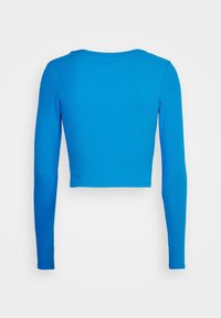 Kort blå langærmet skjorte lavet af ribbet stof med rund halsudskæring og tætsiddende design, uden mønstre og i ensfarvet.