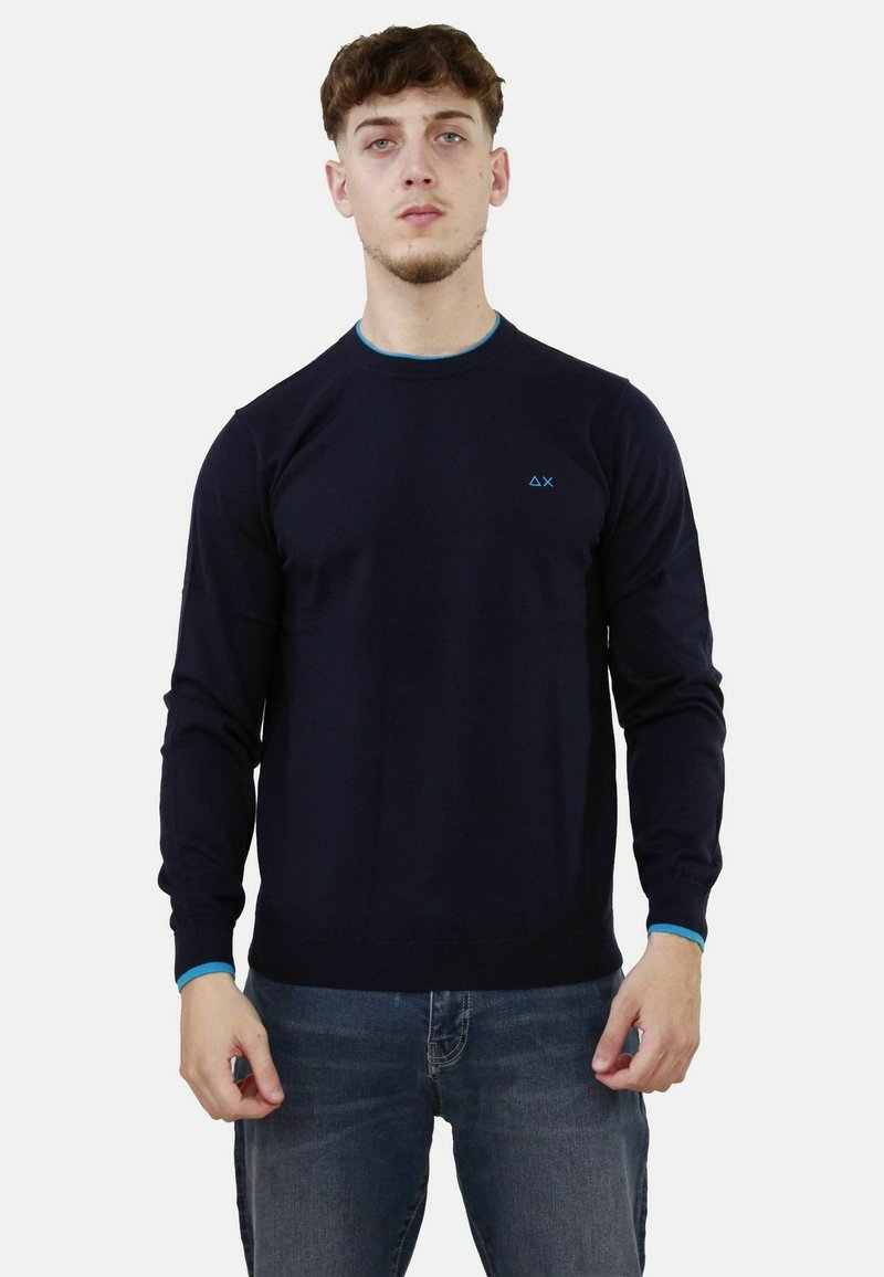Maglione a maglia blu navy con maniche lunghe, collo a giro, e rifiniture a contrasto turchese al collo e ai polsini. Dettaglio del logo discreto sul petto.