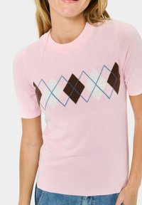 Maglione corto a maniche corte di colore rosa chiaro con collo a girocollo rigato. Presenta un motivo argyle diagonale in marrone, bianco, rosa e blu. Tessuto morbido.