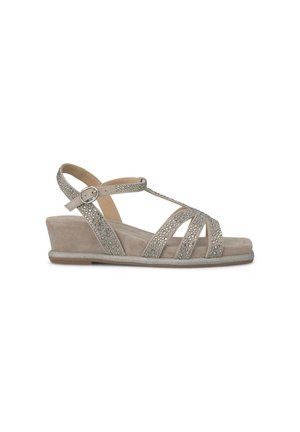 Sandalo con tacco a cuneo beige, caratterizzato da cinturini incrociati con accenti di pietre preziose, superficie in suede testurizzato e un tacco basso e di sostegno.