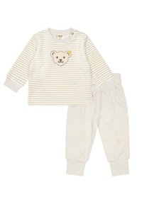 Maglietta a maniche lunghe a righe in crema chiara con applicazione di orsetto; abbinata a pantaloni morbidi color crema con polsini e vita elasticizzati.