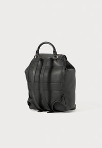 Schwarzer Leder-Rucksack mit strukturiertem Design, ausgestattet mit einem Tragegriff, verstellbaren Schultergurten und einer strukturierten Oberfläche. Akzente aus goldfarbenem Metall.