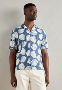 Korte mouwen knoopshirt in blauw met een witte bladerenprint. Gemaakt van lichte stof; heeft een gespreide kraag en een comfortabele pasvorm.