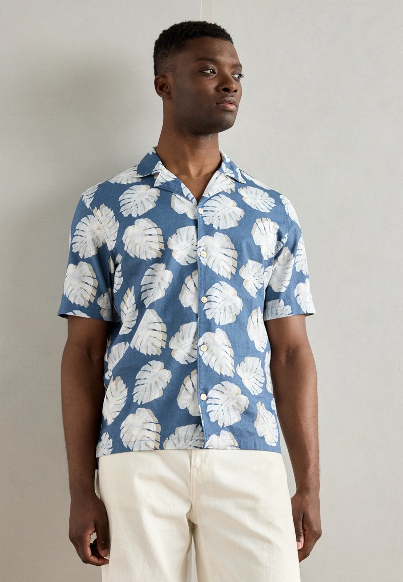 Korte mouwen knoopshirt in blauw met een witte bladerenprint. Gemaakt van lichte stof; heeft een gespreide kraag en een comfortabele pasvorm.