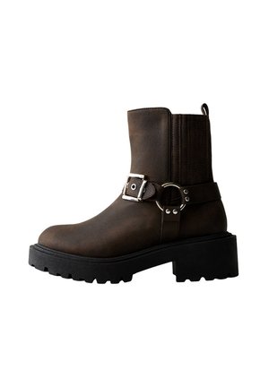Bottes marron à la cheville avec une semelle en caoutchouc robuste, dotées d'une large sangle et d'une boucle en métal. Texture en cuir lisse avec des accents verticaux.
