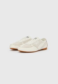 Λευκά καμβά παπούτσια με υφή στο επάνω μέρος, ραμμένες λεπτομέρειες και σόλα από καουτσούκ καραμελέ. Διαθέτουν μινιμαλιστικό σχεδιασμό και κλείσιμο με κορδόνια.