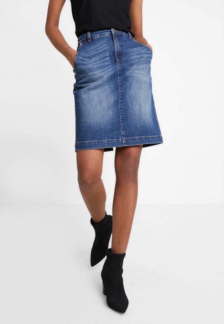 Džínová tužková sukně v středně modré barvě, s dvěma předními kapsami, pasem s poutky na opasek a kontrastním prošíváním. Hladká textura.