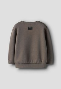 Brązowy długi rękaw bluz z ściągaczami przy mankietach i dolnej krawędzi, z małą czarną łatą z białym napisem na górnej części pleców.