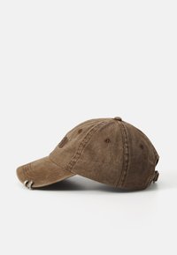 Brown cotton baseball cap with a curved brim, embroidered logo on the front, and a metal adjustable strap at the back. Textured fabric.