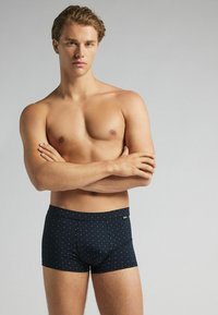 Kraťasy boxerky z tmavě modré látky s tečkovaným vzorem v světle modré barvě. Měkká textura s elastickým pasem a přiléhavým střihem.