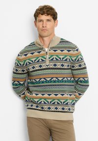 Beige Strickpullover mit einem Viertel-Reißverschluss, der mehrfarbige geometrische Muster in Grün, Blau, Orange und Schwarz aufweist. Weicher Stoff.