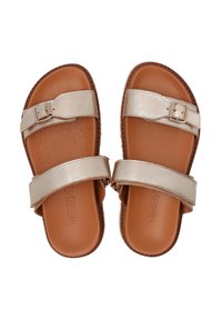 Guld flade sandaler med to brede stropper, der har en spænde-accent. Sålen er brun, lavet af et glat materiale med en tekstureret kant.