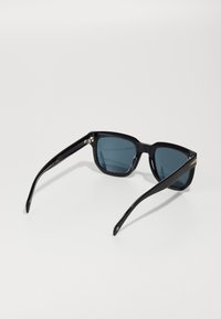 Ochelari de soare dreptunghiulari negri cu lentile de culoare albastru închis. Au un cadru din plastic elegant și brațe drepte, subțiri. Design minimalist fără modele vizibile.