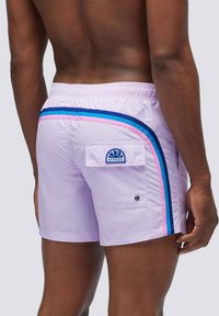 Costume da bagno lilla con una vivace striscia laterale blu e rosa, vita elastica e una tasca posteriore con una patch del logo. Texture liscia.