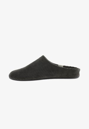 Zapatilla de felpa negra de pana con punta redondeada y suave, textura acanalada y parte trasera baja. Suela de goma plana para mayor comodidad y estabilidad.