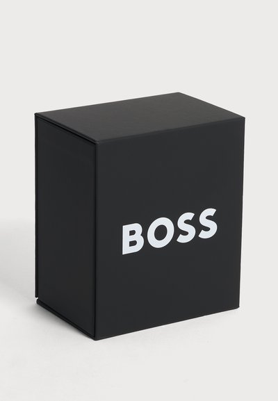 Черен правоъгълен кутия с думата "BOSS" в големи бели букви, центрирани отстрани.