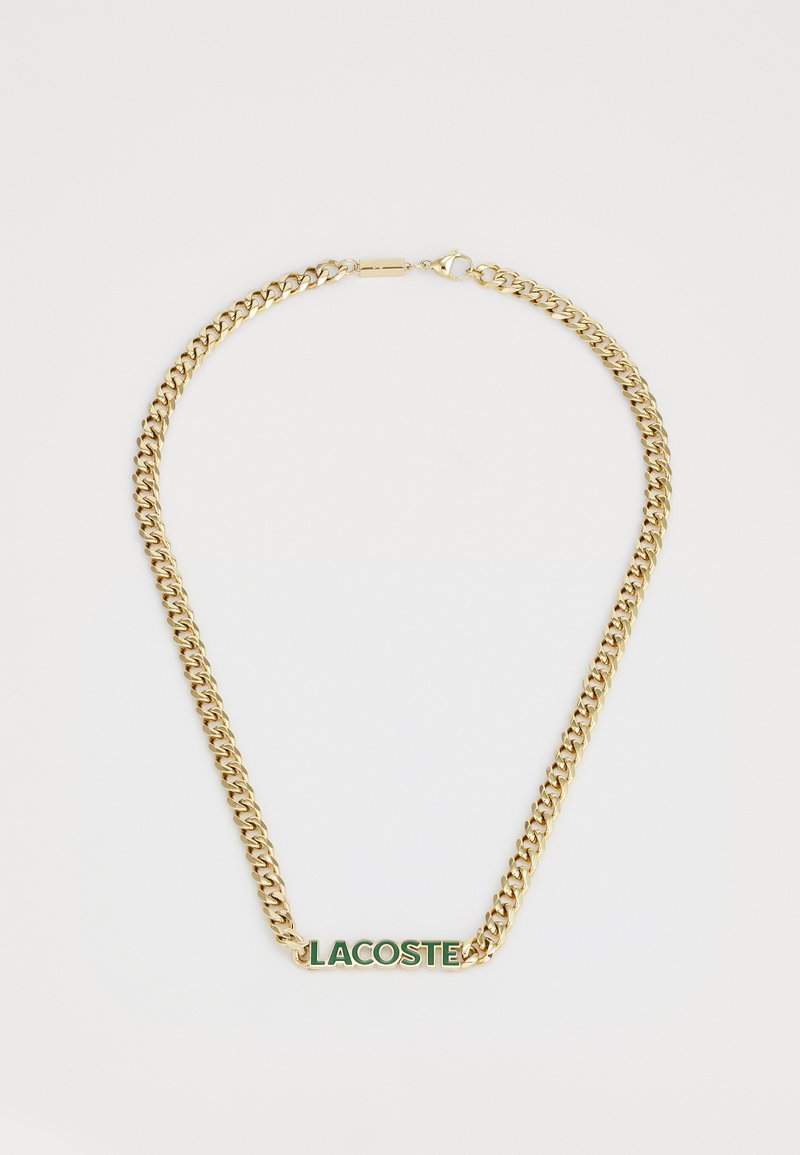Necklace din metal aurit cu zale groase, având un logo "LACOSTE" verde și alb în centru. Închidere cu sistem de prindere sigur.