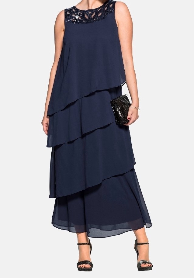Annaver navy layered maxi dress with a beaded neckline, sheer chiffon fabric, and a flowing silhouette, paired with a black clutch and heels.