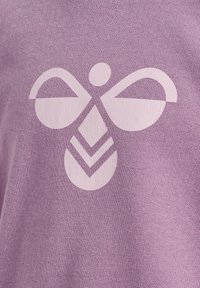 Paarse stof met een gladde textuur, voorzien van een grote witte grafische afbeelding van een symmetrisch abstract bij-vormig logo.