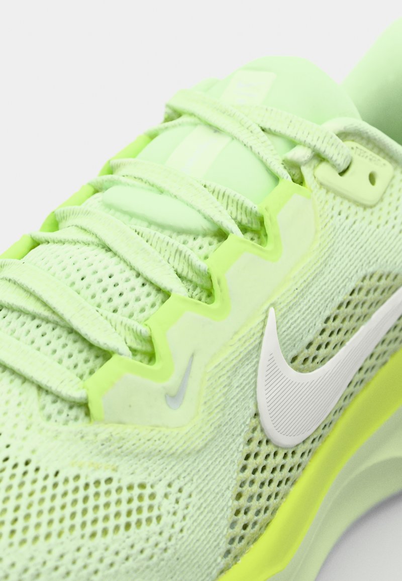 Zapatilla atlética verde lima con parte superior de malla, cordones texturizados y un logo de swoosh blanco. La suela tiene un acento vibrante y un diseño aerodinámico.