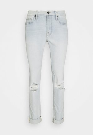 Jeans de denim de lavado claro con corte slim, que presentan detalles desgastados en las rodillas, puños enrollados y un diseño clásico de cinco bolsillos.