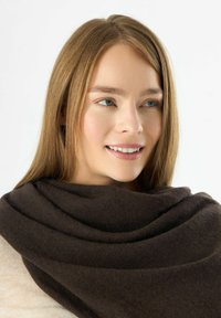 Donkerbruine wrap van zacht materiaal, met een gladde textuur en gedrapeerd ontwerp, gedragen rond de schouders. Minimalistisch uiterlijk.