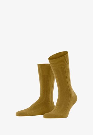 Chaussettes montantes jaune moutarde en tissu tricoté texturé avec des bords côtes pour plus de confort et de maintien.