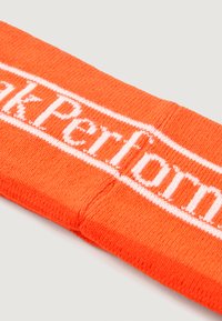 Svetlo oranžna naglavna traka iz pletene tkanine. Ima bel vzorec logotipa prek sredine. Gladka tekstura, pravokotna oblika.