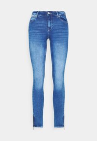 Jeans de mezclilla en un lavado azul medio con corte ajustado. Presenta dos bolsillos frontales, un tobillo con cremallera y un cierre clásico de botones.