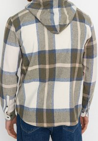 Camicia in flanella a quadri in tonalità tenui di oliva, blu e beige. Presenta un cappuccio, polsini con bottoni e una texture morbida.