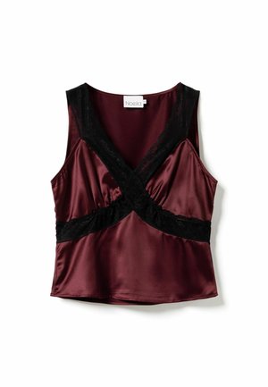 Bezramionkowa satynowa bluzka w ciemnym burgundzie z czarną koronką krzyżującą się z przodu i wokół talii, ułożona na białym tle.