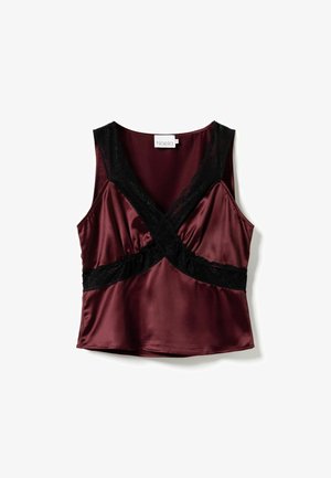 Bezramionkowa satynowa bluzka w ciemnym burgundzie z czarną koronką krzyżującą się z przodu i wokół talii, ułożona na białym tle.