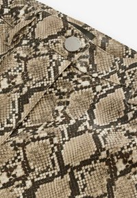 Hnědá látka s hadím vzorem, texturovaný povrch a kovový patent. Design obsahuje kontrasty černé a béžové barvy.