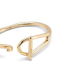 Pulsera de metal en tono dorado con una forma ovalada sencilla y una textura retorcida. Los detalles notables incluyen un gancho y un acento de barra plana.