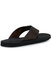 Sandalia de flip-flop de cuero marrón con una banda superior ancha, suela de goma negra texturizada y tacón ligeramente elevado. Fabricada en España.