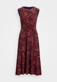 Klänning med ärmlös design, lila bas med intrikata röda och gröna paisleymönster, och en vriden knutdetalj vid midjan.