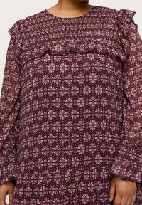 Šatečky s maroon vzorem, s volánovými rameny a dlouhými průhlednými rukávy, s květinovým potiskem v purpurové a bílé barvě, v texturovaném materiálu.