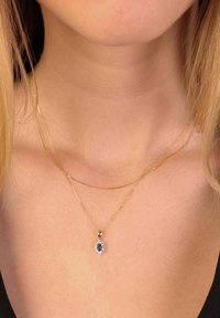 Gouden ketting met twee schakels, met een centraal hanger met een blauwe steen omringd door heldere accenten.