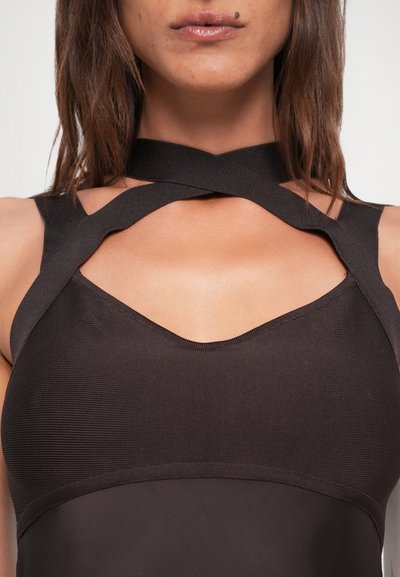 Zwarte sporttop met een V-hals, textuurstof en gekruiste bandjes, die de minimalistische uitstraling en ademend materiaal benadrukt.