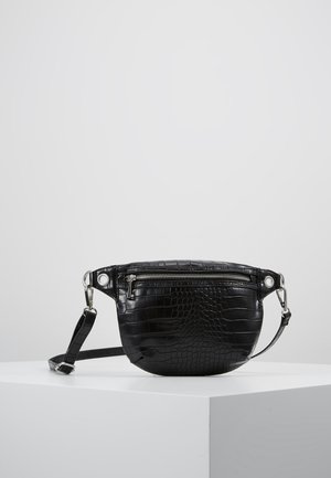 Schwarze Gürtel-Tasche aus Kunstkrokodilleder mit vorderer Reißverschlusstasche und verstellbarem Riemen, liegend auf einer weißen Oberfläche.