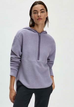 Felpa con cappuccio viola in pile, dotata di chiusura zip, fessure laterali e maniche lunghe con risvolti. Tessuto morbido e vestibilità rilassata.