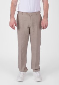 Pantaloni in lino marrone chiaro con taglio dritto, caratterizzati da una chiusura con bottone frontale e passanti per cintura, indossati con sneakers bianche.