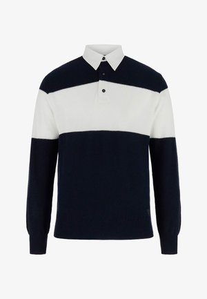 Must-valge triibuline pika varrukaga kootud kampsun valge kraega ja kahe musta nööbiga kaelal.