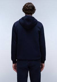 Felpa con cappuccio blu navy, con una texture liscia e polsini a coste. Presenta un design semplice con cappuccio visibile e senza marchi visibili.