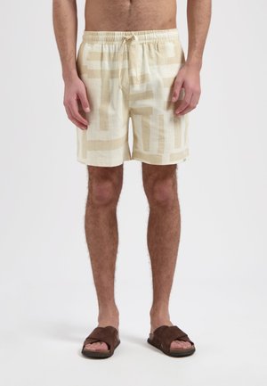 Linnen zwembroek in lichtbeige met een geometrisch crèmekleurig patroon. Elastische tailleband met trekkoord, zijzakken en knielange snit.