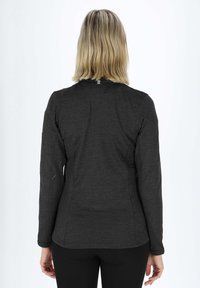 Top nero a maniche lunghe con tessuto texturizzato, design aderente e colletto alto. Caratteristiche includono una cucitura sul retro e un'etichetta di marca minimalista.