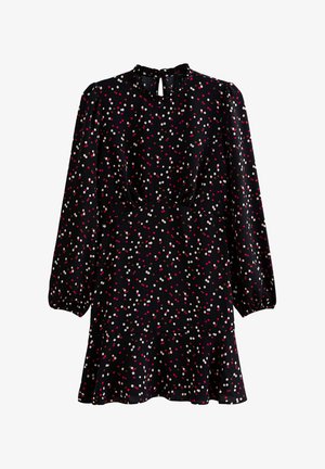 Vestido negro de mangas largas, con escote redondo y un ojal en la parte de atrás, adornado con lunares coloridos y un dobladillo acampanado.